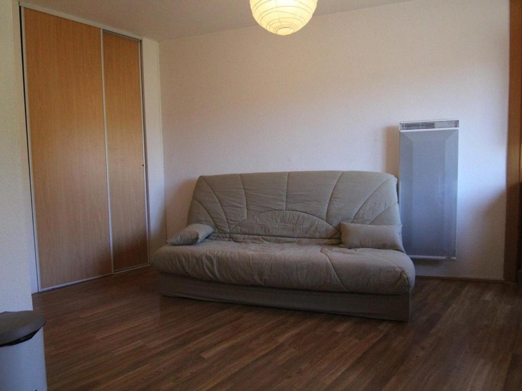 een woonkamer met een bank in de hoek van een kamer bij Appartement Huez, 1 pièce, 4 personnes - FR-1-405-334 in Huez