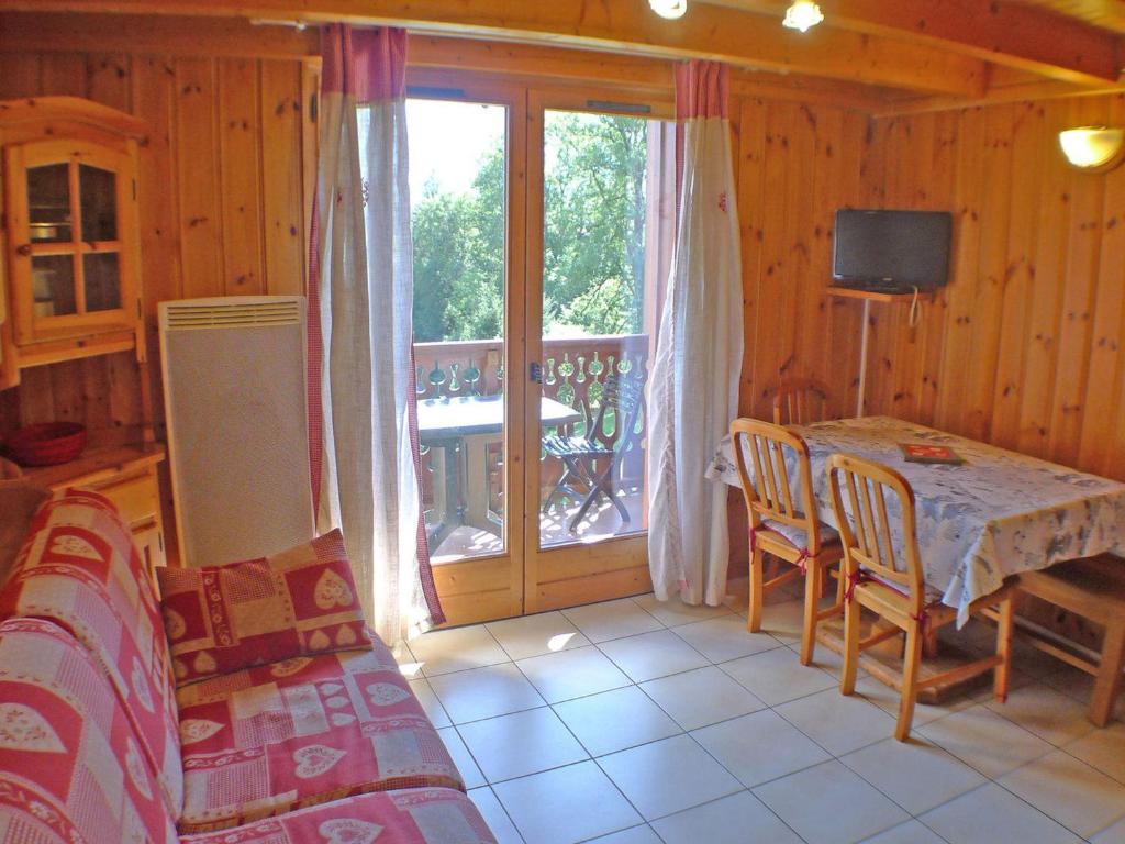 d'un salon avec une table et un balcon. dans l'établissement Appartement cosy à Morillon pour 6 pers, balcon, lave-vaisselle, machine à laver - FR-1-629-132, à Morillon