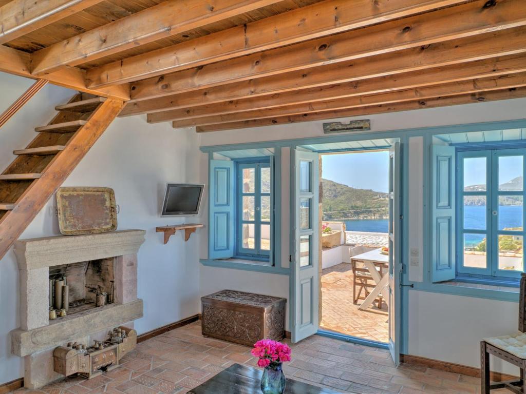 a living room with a fireplace and a wooden ceiling at Eirini Luxury Hotel Villas in Grikos