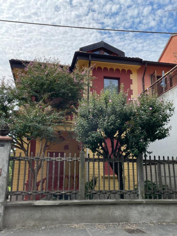 uma casa com uma cerca e árvores em frente em B&B In Liberty Style em Settimo Milanese