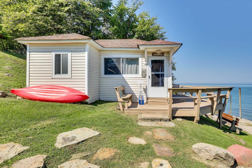 una piccola casa con una barca rossa davanti di Scenic Geneva Cottage with Lake Erie Beach Access! a Geneva