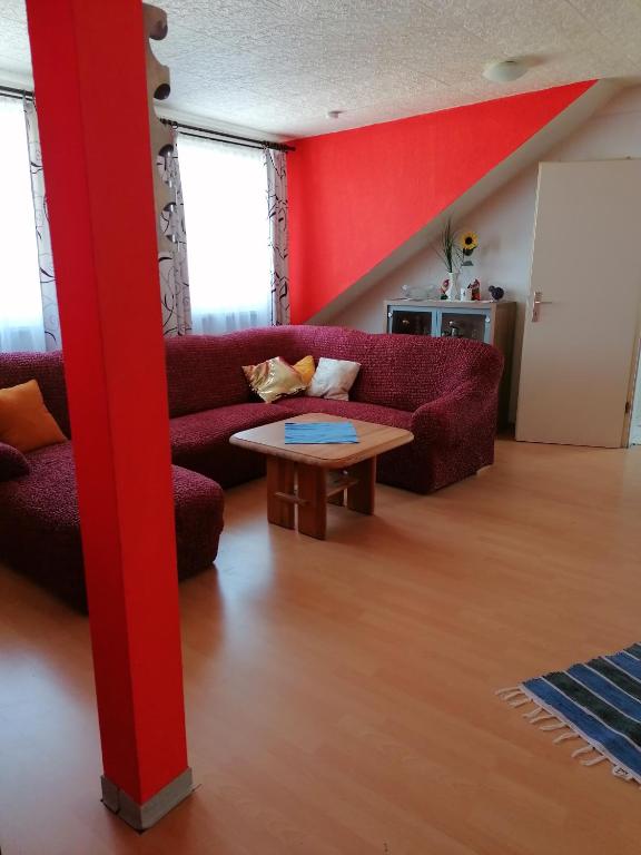 sala de estar con sofá rojo y mesa en Apartment Bonnie, en Pirmasens