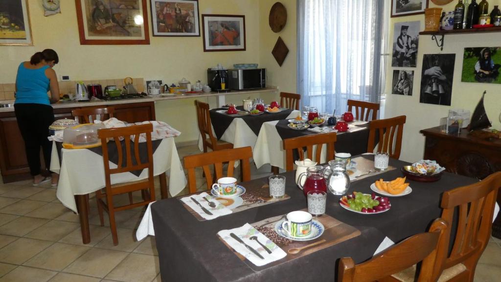 uma sala de jantar com duas mesas com comida em B&B Oliena em Oliena
