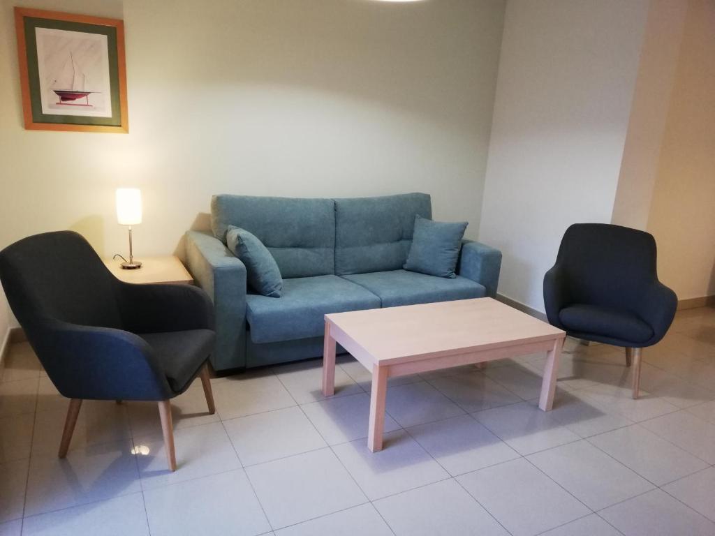 レスカラにあるApartamentos Mestralのリビングルーム(青いソファ、椅子2脚付)