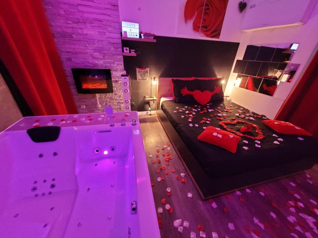 アヴィニョンにあるLove & Spaのピンクの照明が付いたベッドが備わる客室です。