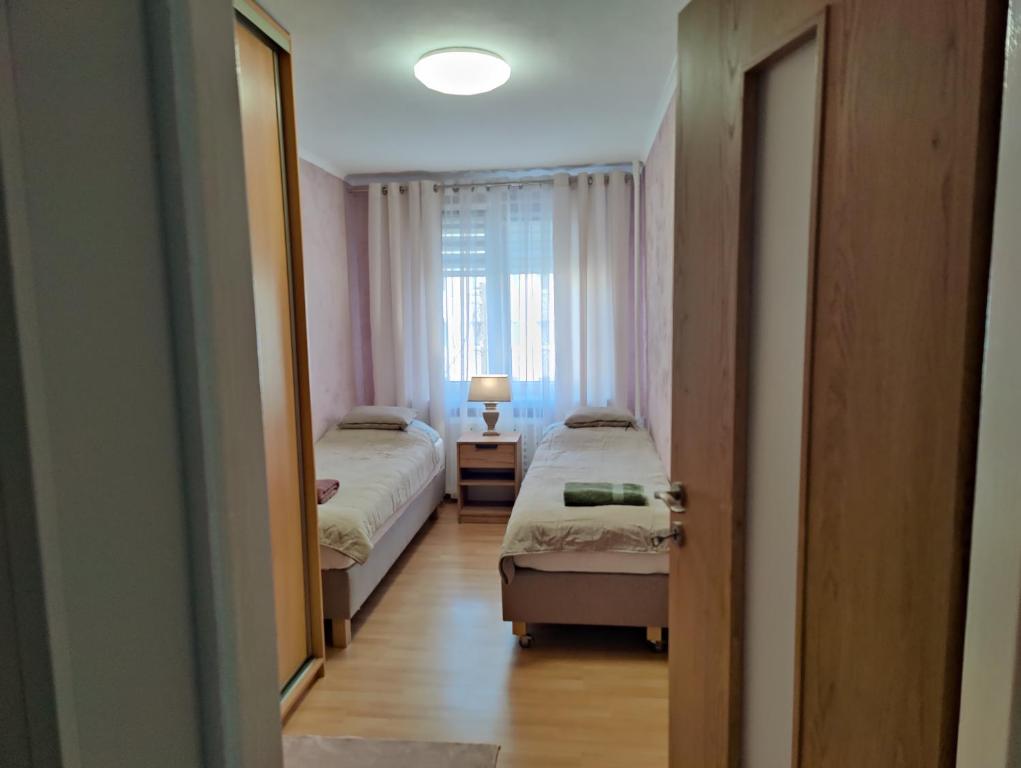 1 dormitorio con 2 camas y ventana en Dwupokojowe mieszkanie Nowy Dwór Mazowiecki en Nowy Dwór Mazowiecki