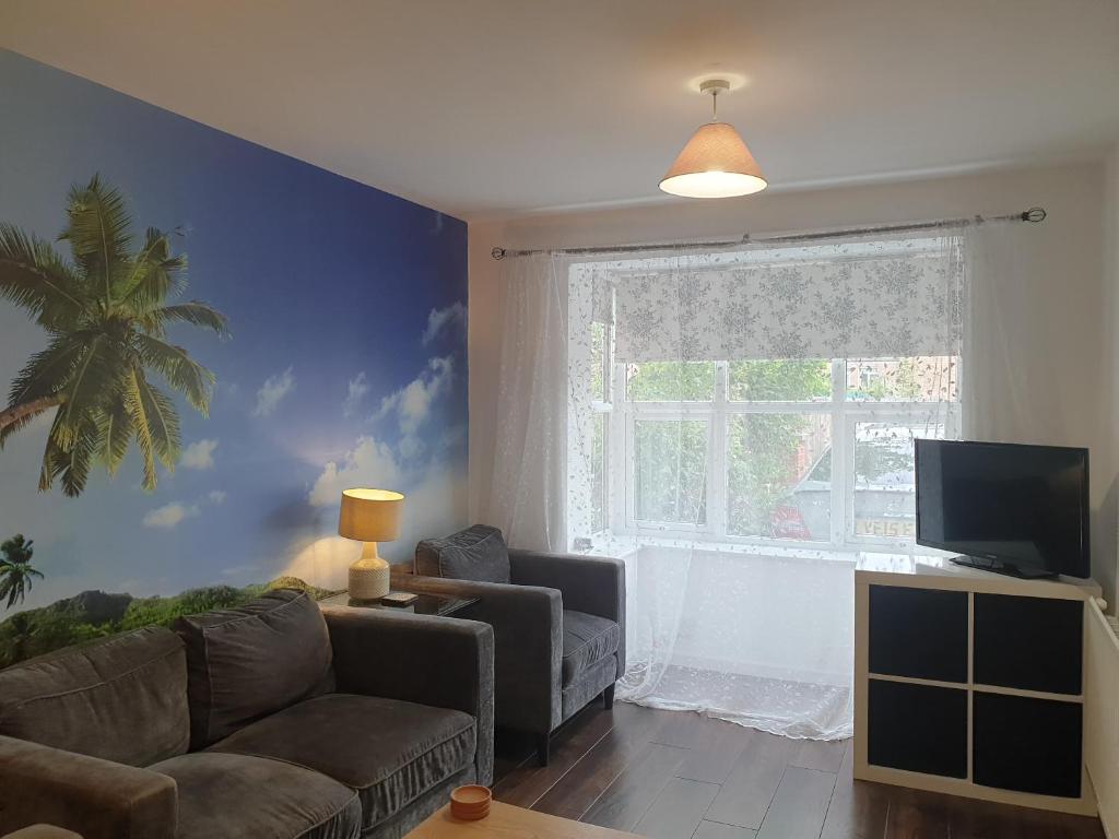 a living room with a couch and a window at BrumStay UK - 4 Bedrooms House with Garden, Parking and Fibre Broadband with speed upto 250mbps in Birmingham