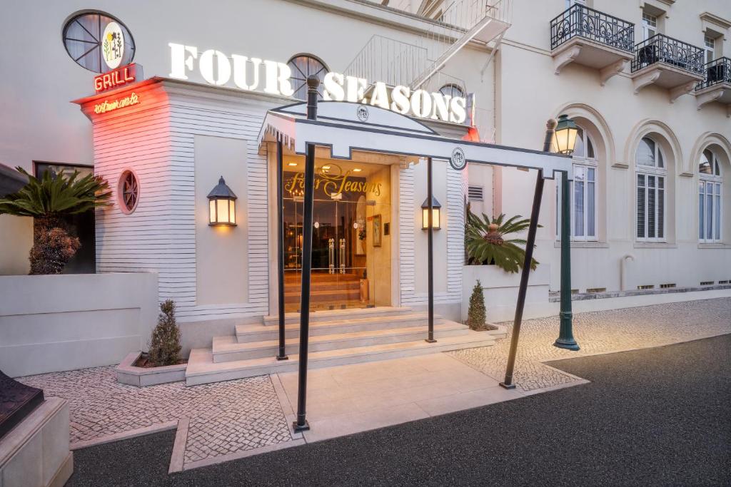a hotel entrance with a sign that reads four sisters at Palácio Estoril Hotel, Golf & Wellness in Cascais