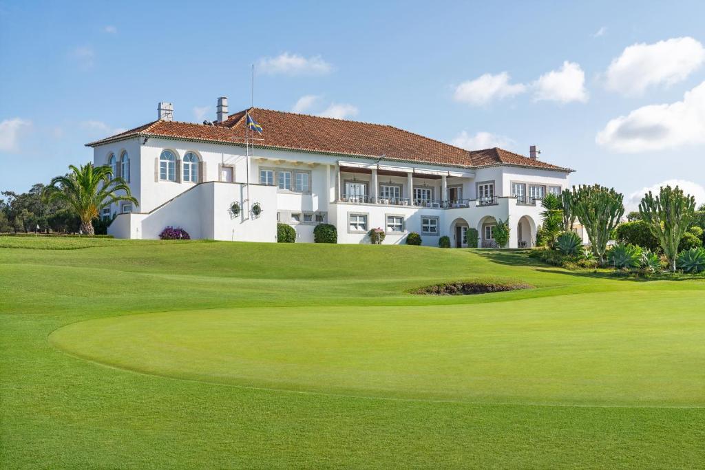 a house on a golf course with a green at Palácio Estoril Hotel, Golf & Wellness in Cascais