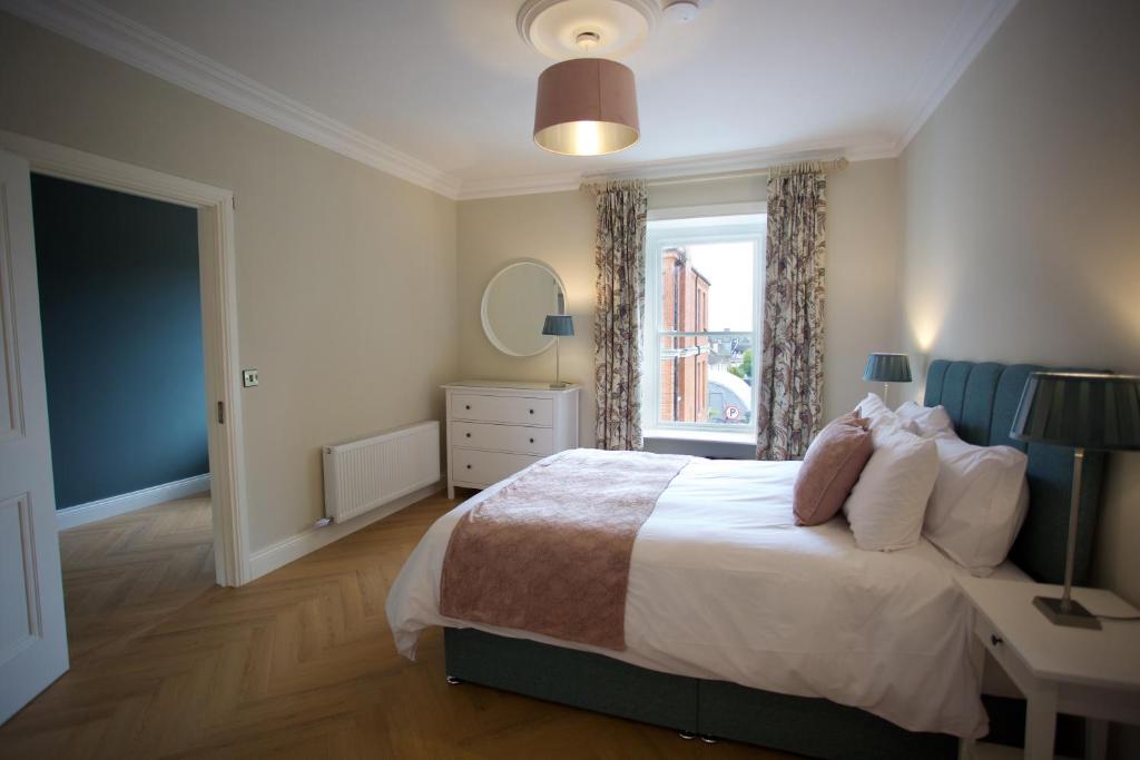 - une chambre avec un grand lit et une fenêtre dans l'établissement Townhouse Stay - St George's Terrace, à Carrick-on-Shannon