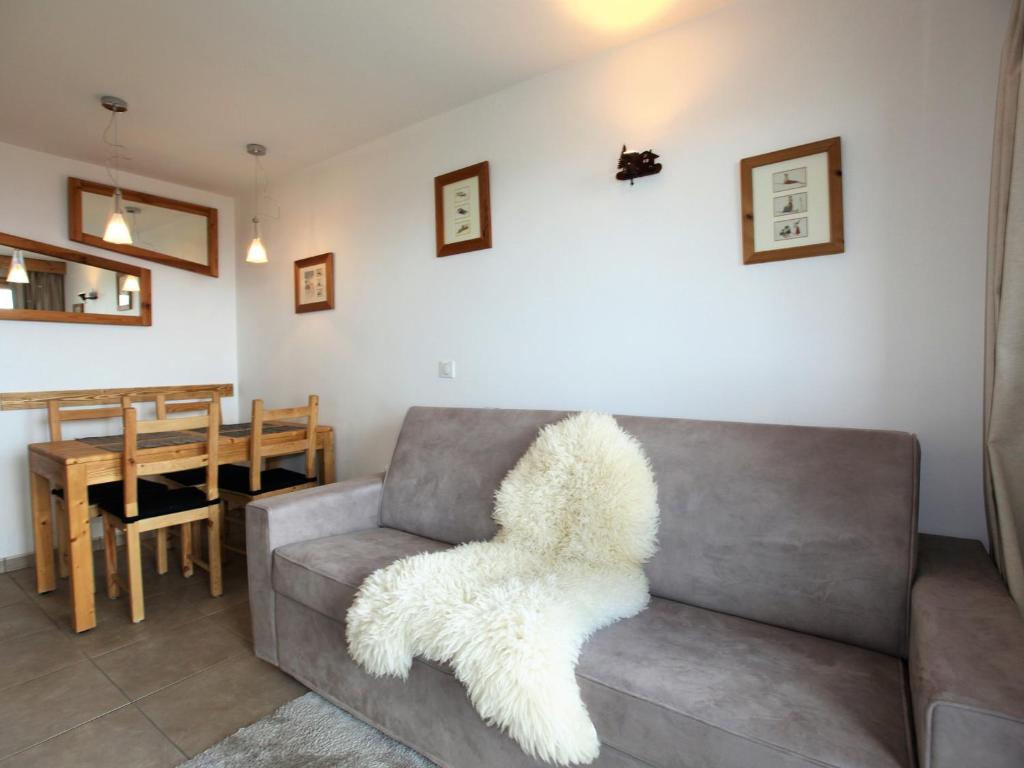 a living room with a gray couch with a white furry seat at Charmant studio cabine avec WiFi à Avoriaz - FR-1-314-159 in Morzine
