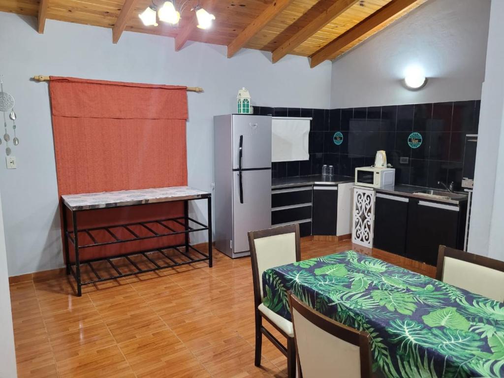 a small kitchen with a table and a refrigerator at Amplio departamento para 2 personas in Neuquén