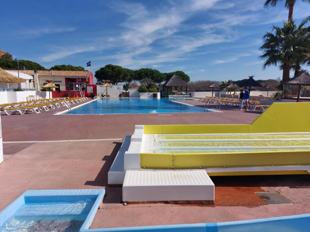 uma piscina com um banco amarelo e branco ao lado em le lac des rêves em Lattes