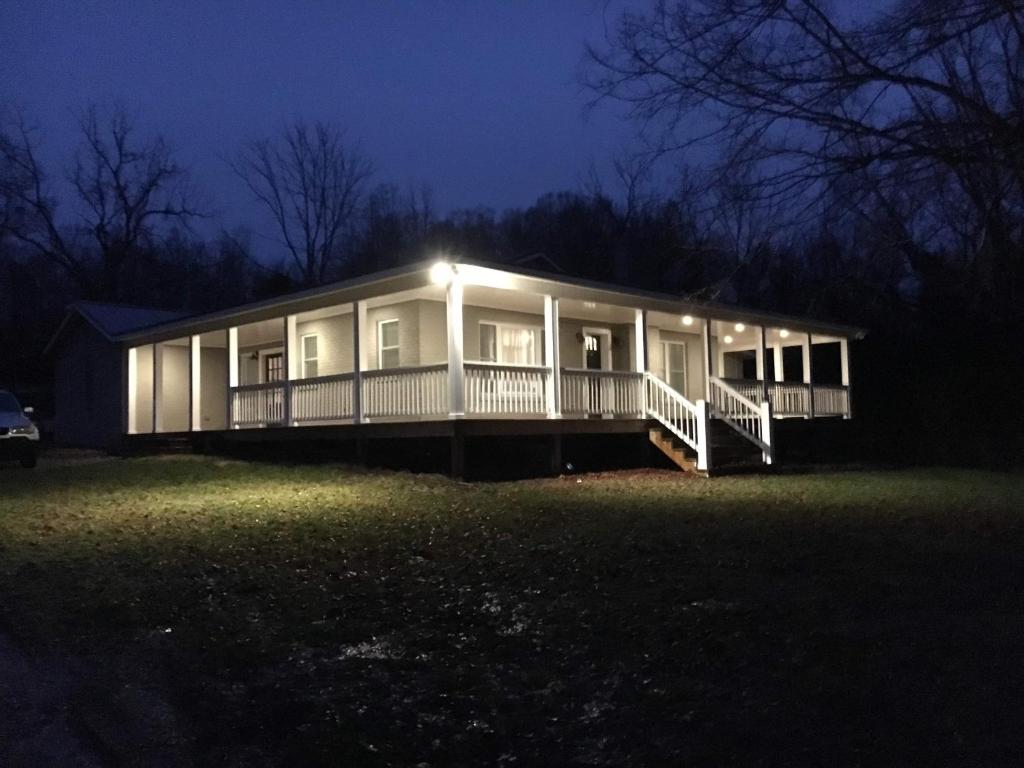 una grande casa con portico di notte di The Cottage at Broad Hill Run Farm a Lenoir City