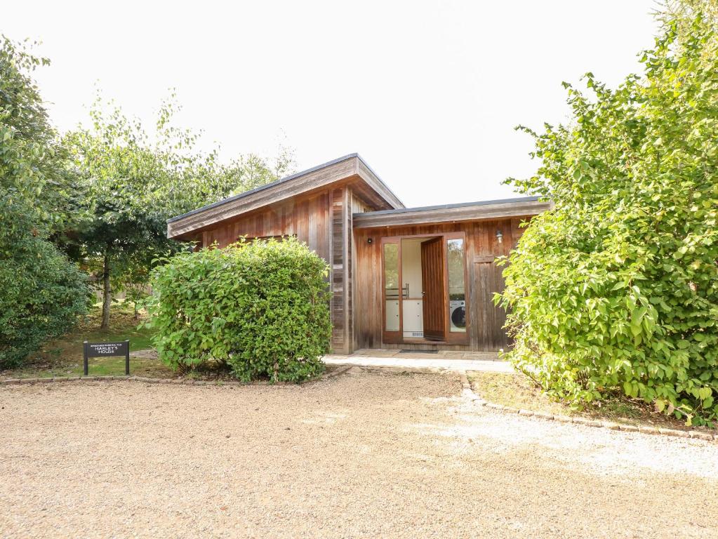 a wooden house with a sign in front of it at Harley's House in Oakham