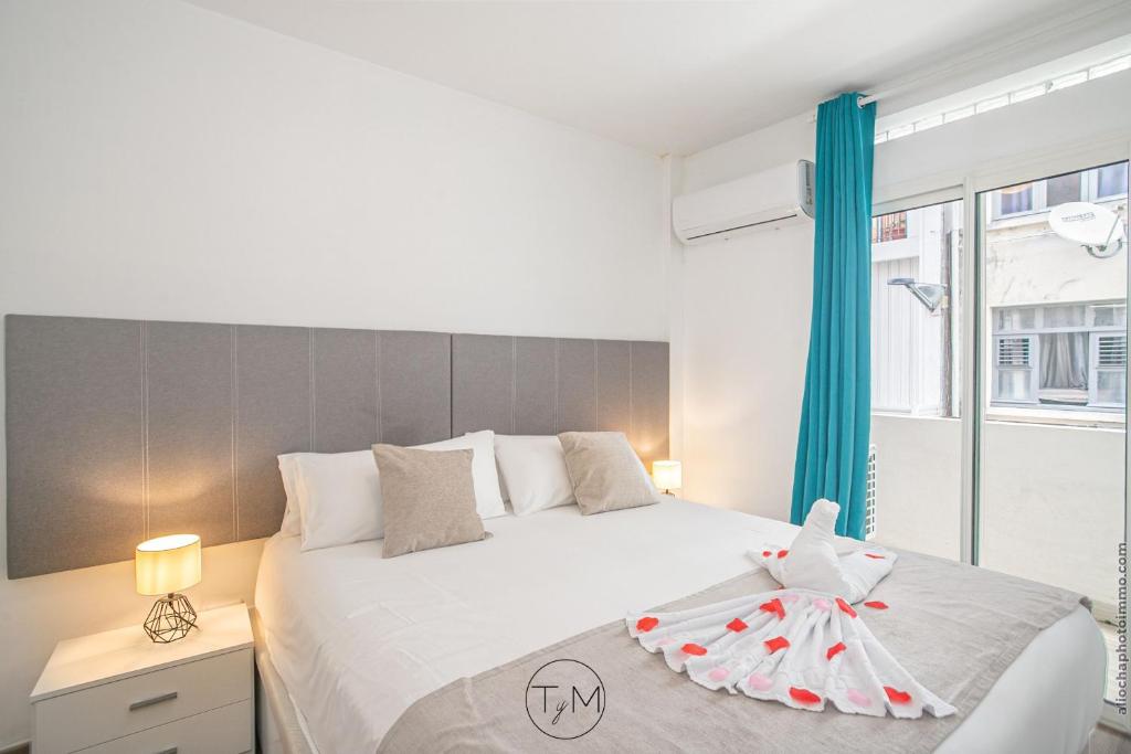 Un dormitorio con una gran cama blanca y una ventana en Carré d'as, en Fort-de-France