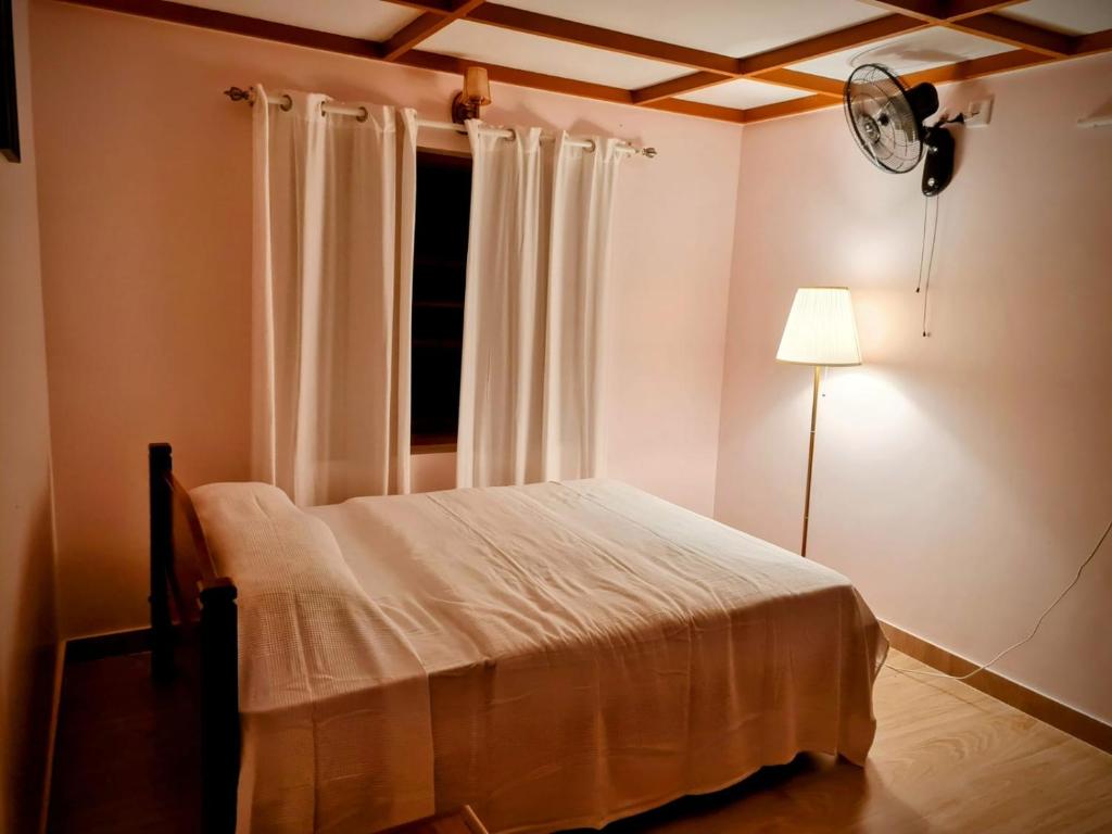um quarto com uma cama e um relógio na parede em Kaanayi heritage home em Kokkānisseri