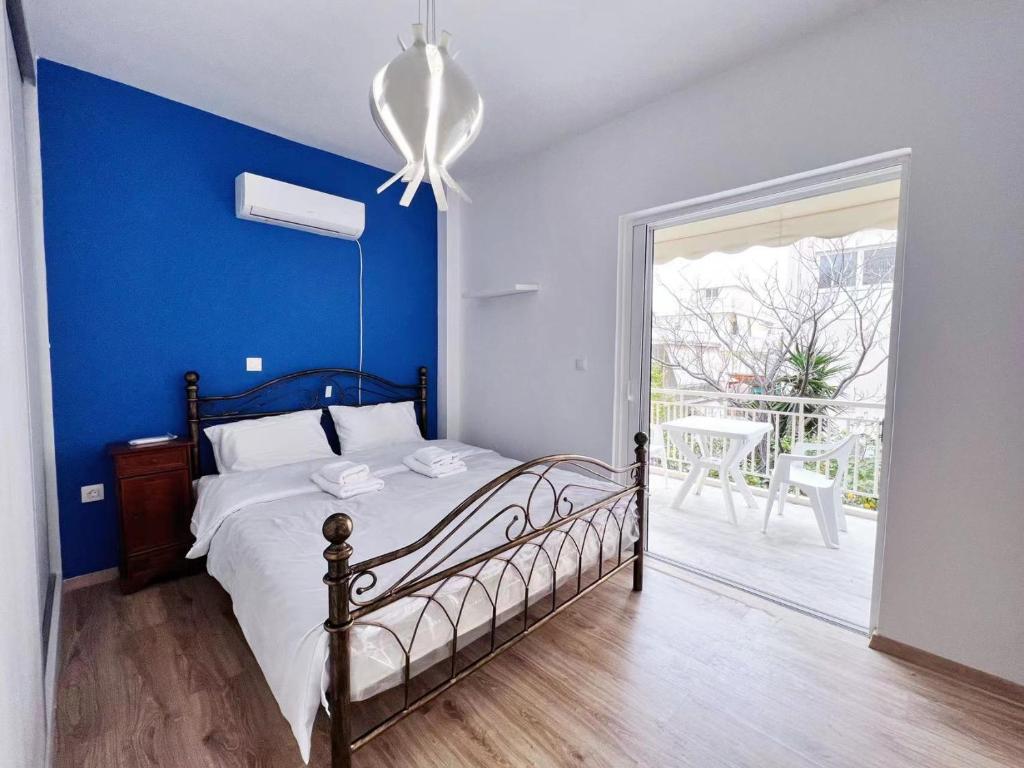 um quarto com uma cama com uma parede azul em WSD Faliro New 1BD Apartment with Bal Near Alimos Marina em Atenas
