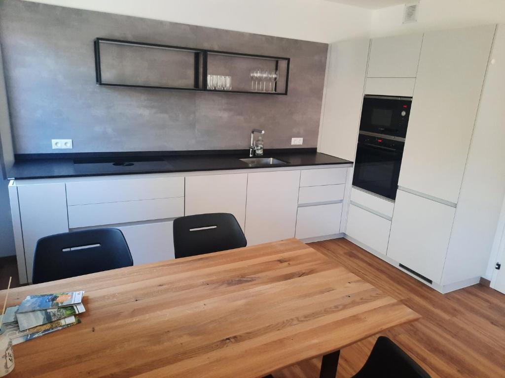 cocina con mesa de madera y 2 sillas en Apartment by Bruno, en Innsbruck