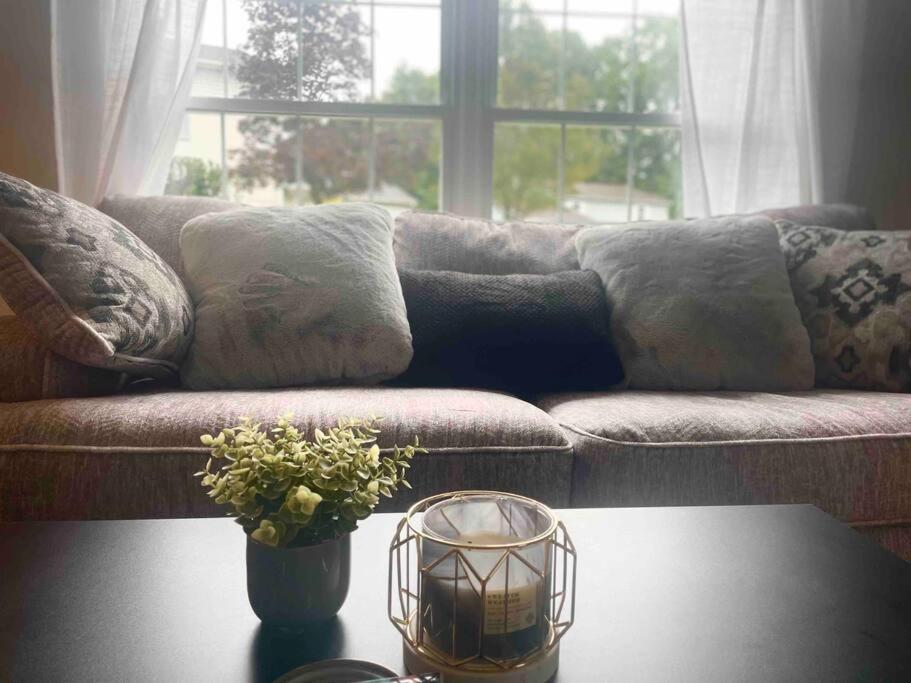 a living room with a couch and a table with a candle at New Stylish Condo Monthly Rental in Reminderville