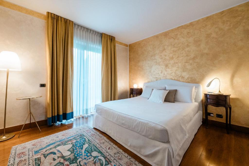 a bedroom with a white bed and a large window at Airport BEA Rooms in Azzano San Paolo