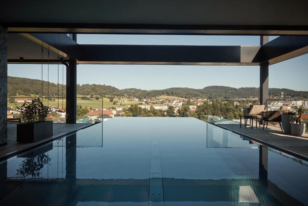 a swimming pool with a view from a house at Impulshotel FREIGOLD in Freistadt