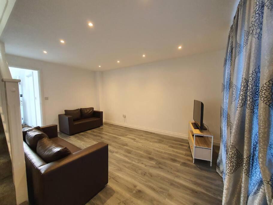 a living room with a couch and a television at Perfect for family getaways in West Thurrock