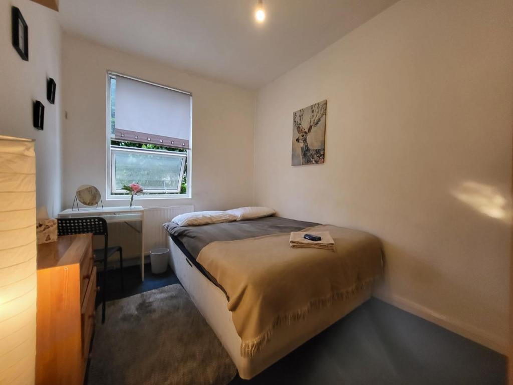 a bedroom with a bed and a desk and a window at Quiet Room Near Arsenal Stadium Islington Zone 2 Cental in London