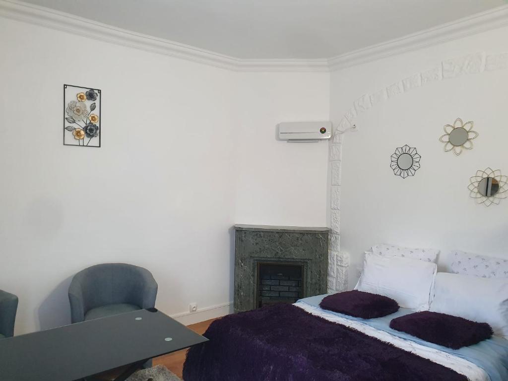 biała sypialnia z łóżkiem i krzesłem w obiekcie Studio/Bourget/CDG/Villepinte w mieście Aulnay-sous-Bois