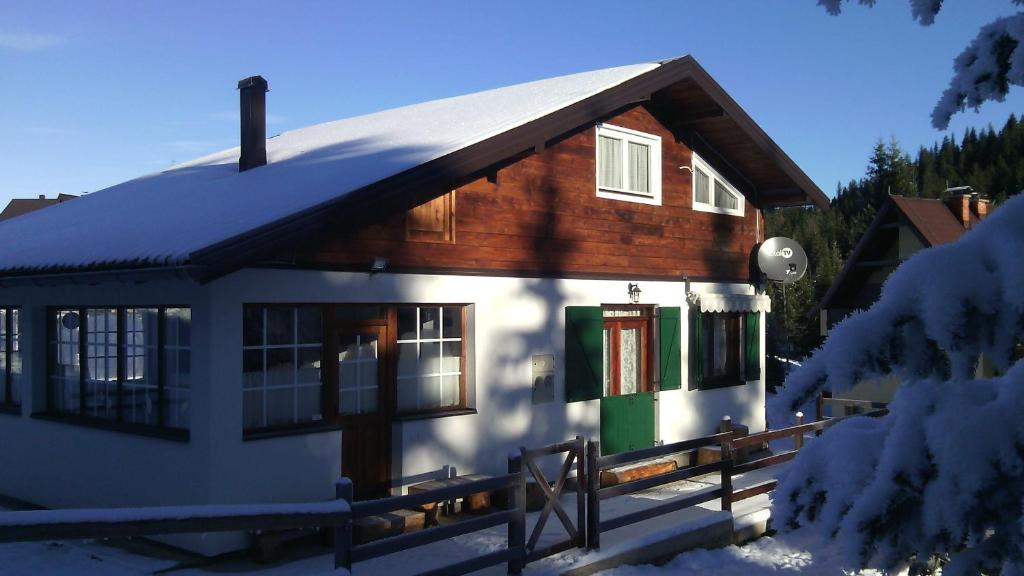 mały domek ze śniegiem na dachu w obiekcie Chalet Pahulja w mieście Jahorina