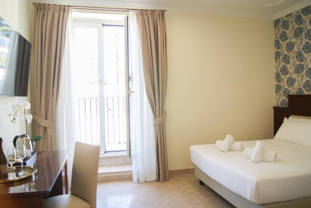 una camera d'albergo con un letto e una grande finestra di Glam Luxury Rome a Roma