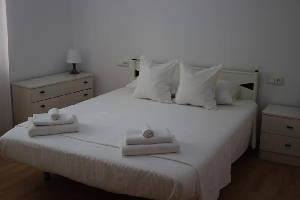 een slaapkamer met een wit bed en 2 handdoeken bij Amplio apartamento de obra nueva con A/C in Mataró