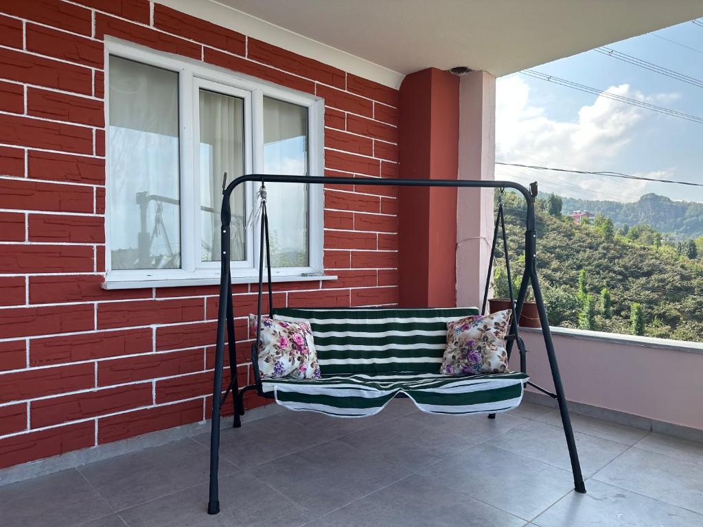 a porch swing with pillows sitting on a balcony at Tirebolu Kaplan Apartman 