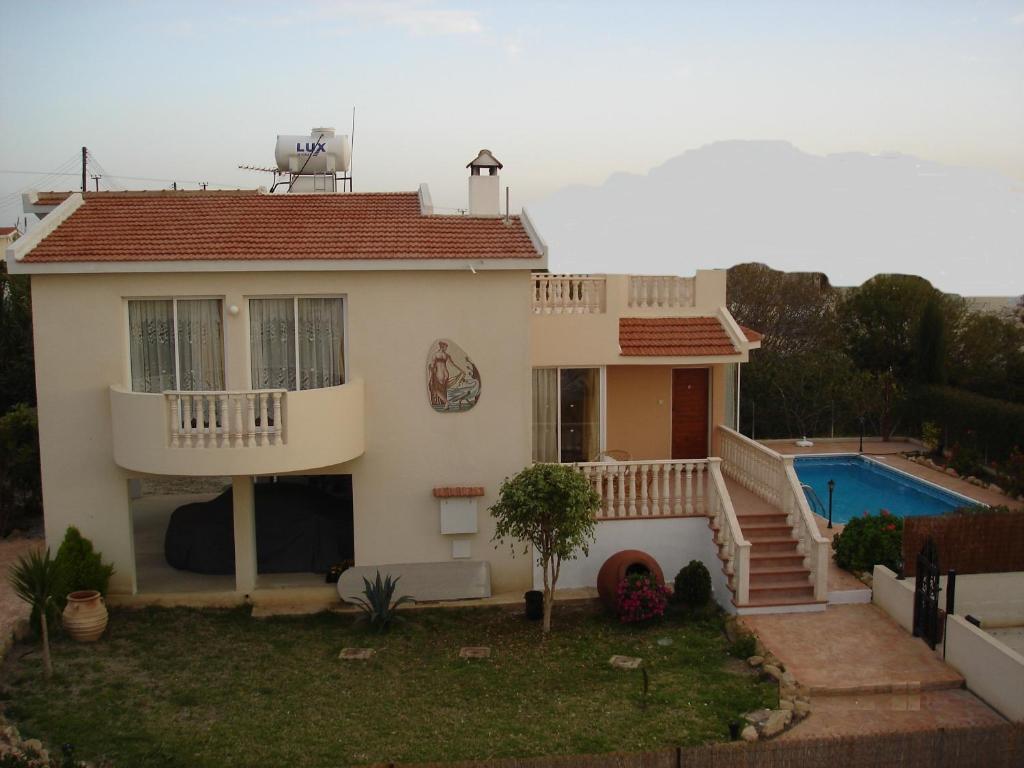 a house with a swimming pool in front of it at Villa Theodora in Paphos City