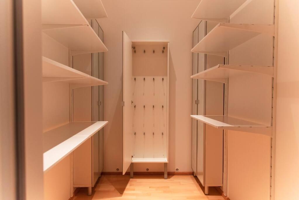 a walk in closet with white shelves and a door at Luxury CityApartment 7 in Vienna