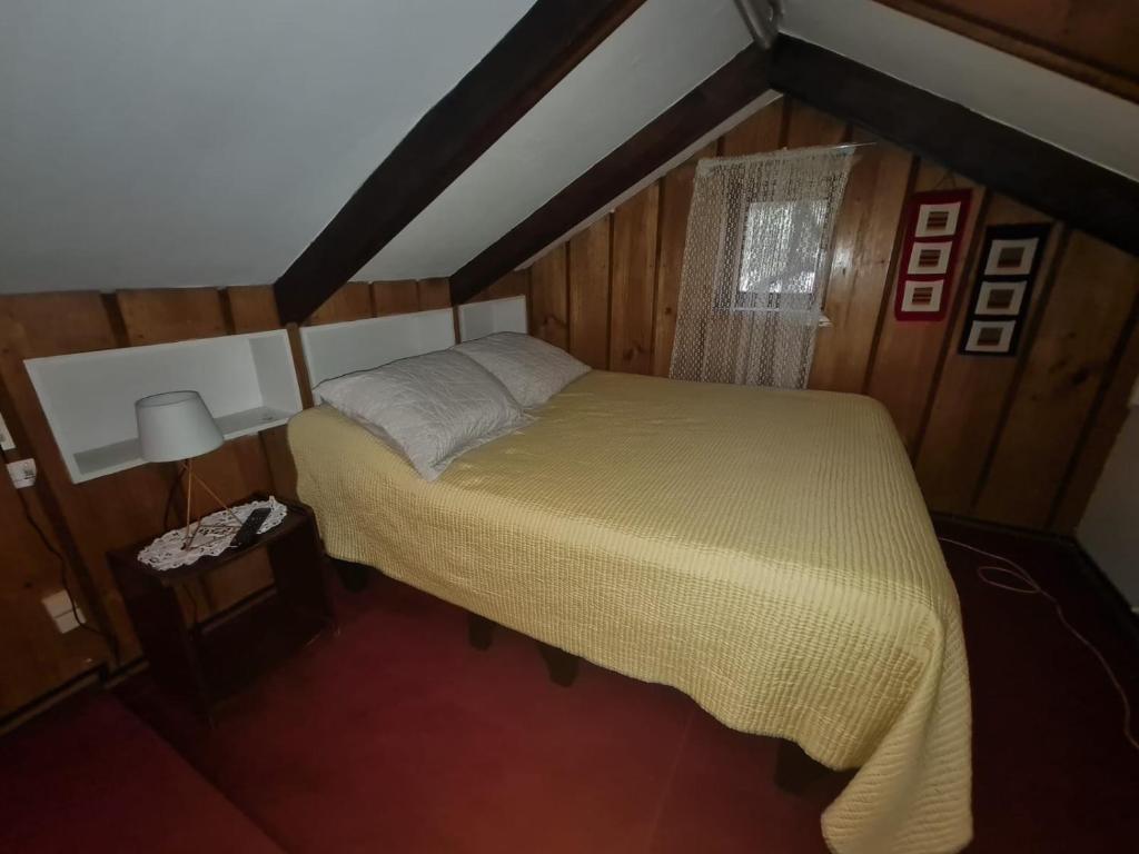 um pequeno quarto com uma cama num quarto em Hospedaje Myrtha em Temuco