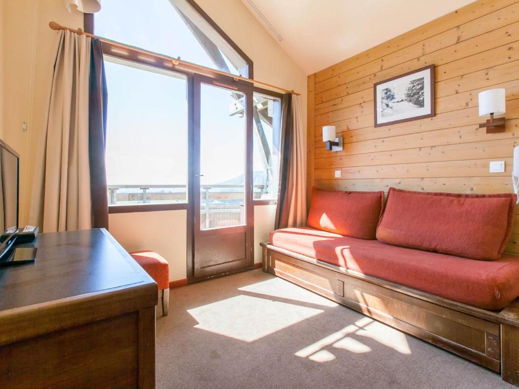 a living room with a red couch and a large window at Studio Avoriaz, 1 pièce, 4 personnes - FR-1-314-219 in Morzine