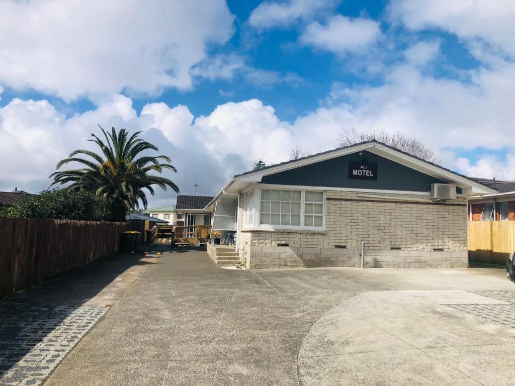 een gebouw met een palmboom ervoor bij Ali Motel in Auckland