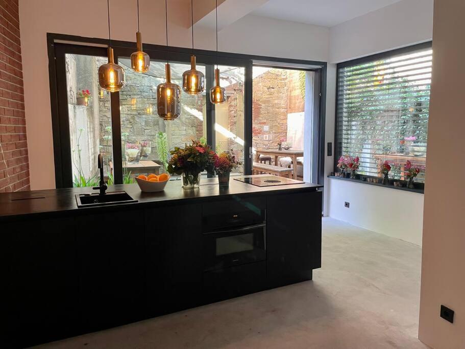 a kitchen with a black counter and a large window at Der Vitihof Loft in Osnabrück