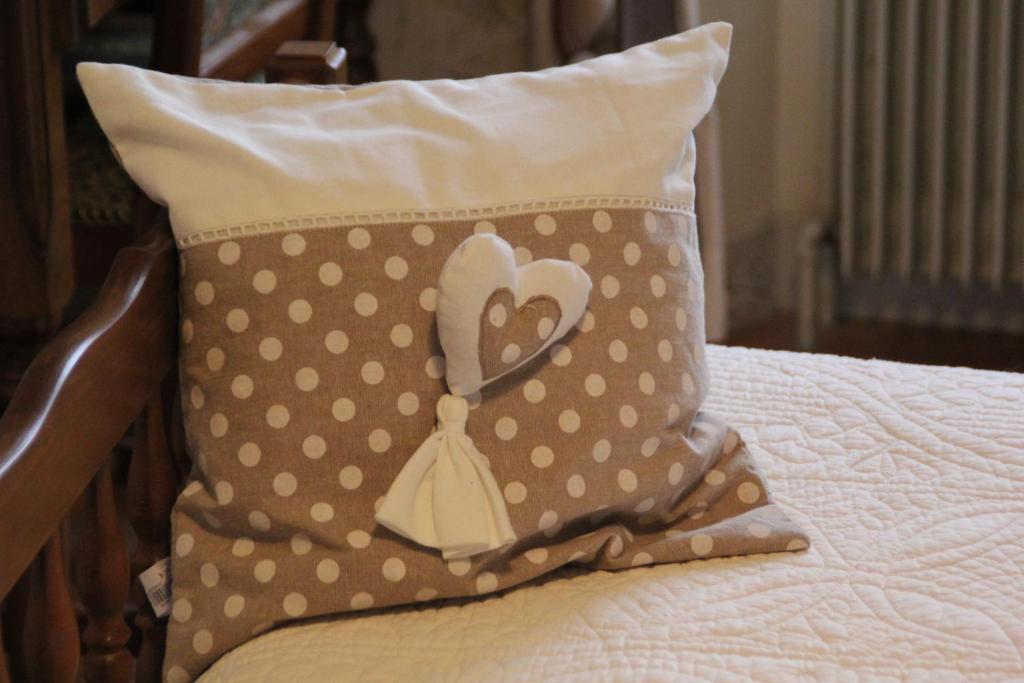 a pillow with a heart on it sitting on a bed at La Maison des Chats in Saint-Mary-le-Plain