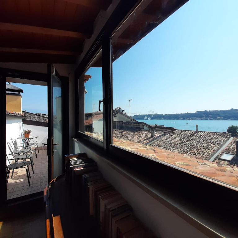 サロにあるLoft trabucco panoramico 4 camere 7posti letto vista lago e centro storicoの海の景色を望む窓付きの客室です。