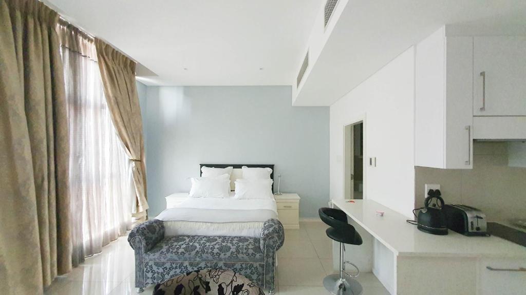 - une chambre avec un lit, un bureau et une fenêtre dans l'établissement iTowers Studio-Suite, à Gaborone