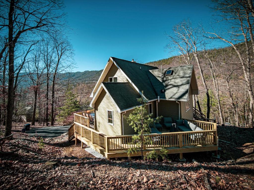 a house with a large deck in the woods at Mtn Views - Sauna - Hot Tub - Health - Wellness in Massanutten