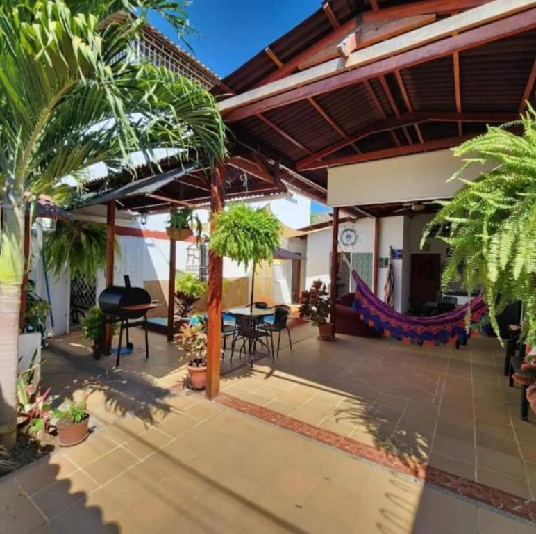 un patio con mesa, sillas y palmeras en Rancho Ayala, en Santa Marta