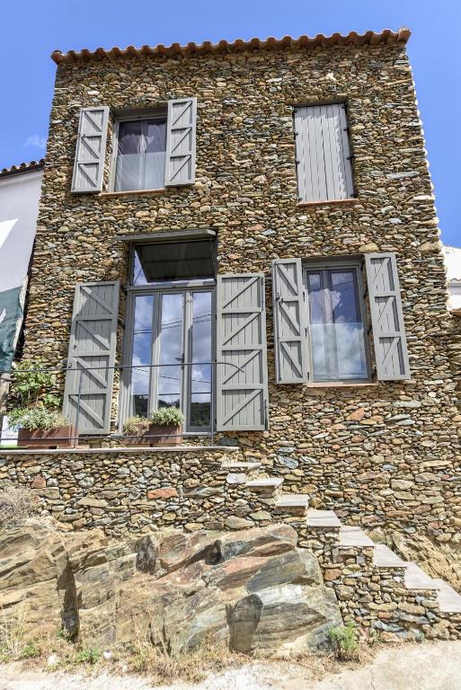 a stone building with windows on the side of it at Casa de Piedras by SIERRA VIVA desing in Cortelazor