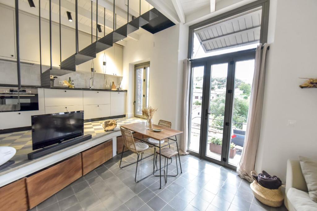 a kitchen with a dining table and a large window at Casa de Piedras by SIERRA VIVA desing in Cortelazor