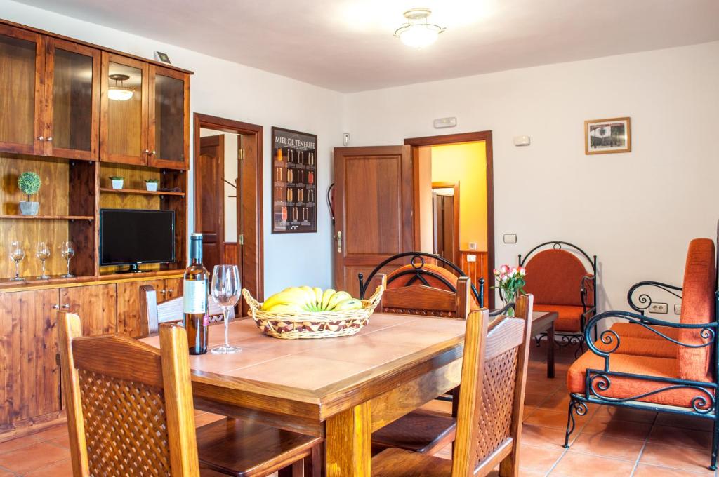 uma sala de jantar com uma mesa de madeira e cadeiras em HolidaynorthTenerife Caserío Rural Los Charcos em Icod de los Vinos