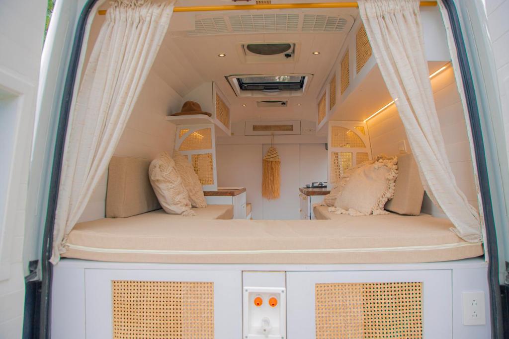 an interior view of a campervan with a bed and curtains at Campervan Bogota Rolling Suite in Bogotá