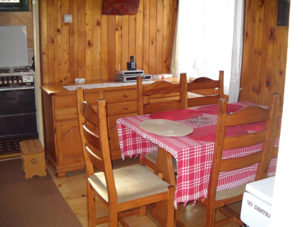 a dining room table with a red and white table cloth at Old Town House in Žabljak