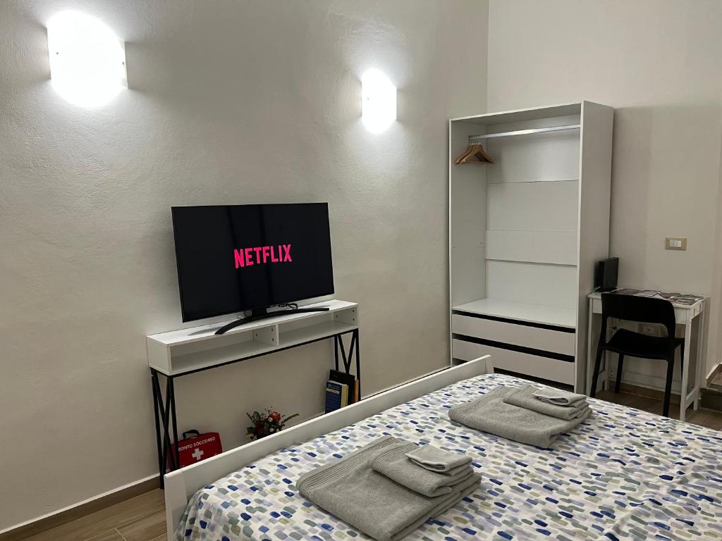 sypialnia z łóżkiem z telewizorem i łóżkiem sidx sidx sidx w obiekcie AL 106 Apartment [Free Wi-fi 5 min dalla Stazione] w mieście Prato